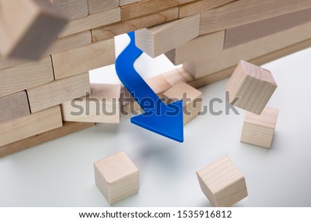 Arrow Breaking Through Wall Made Of Wooden Blocks On White Background