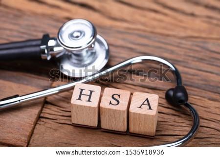 HSA Health Savings Account Wooden Blocks Near Stethoscope On Wooden Table Royalty-Free Stock Photo #1535918936