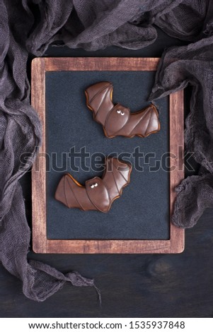 Homemade gingerbread cookies in the form of   bat on dark background. Halloween holiday concept. Top view with copy space