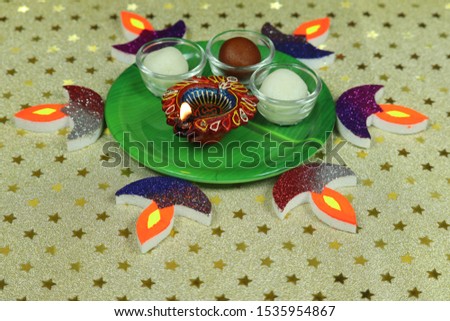 Deepawali Diwali Celebrations with Diya Sweets and Decorations Golden Yellow Background Close Up