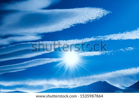 High mountain peak covered with snow in winter . Snow mountain and blue sky . Cloud landscape  . . Religion background . Blue sky with clouds and sun