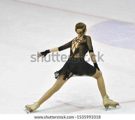 Girl skater skates on ice sports arena
