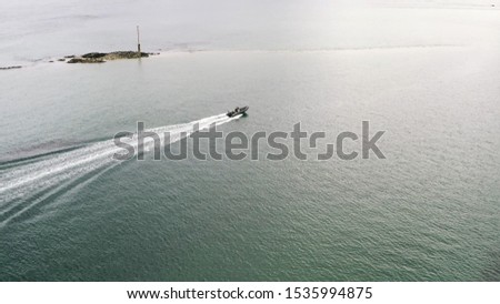 Aerial view of white motorboat and red water biking sailing on the sea or river in sunny day. Action. Summer resort
