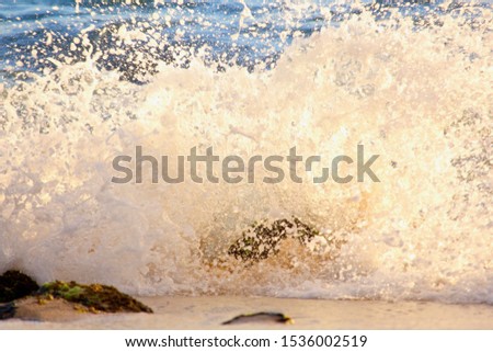 Waves crashing and splashing on the shore over stones