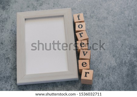 Beautiful cute lovely white pastel frame with wood cube FORVER letter on black background. Photo for couple and lover,family and friends, romantic valentine. Love concept for happy valentine.