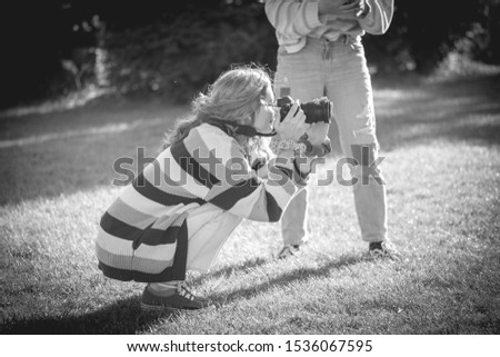 Teen girl photographs in a park. Black and white image