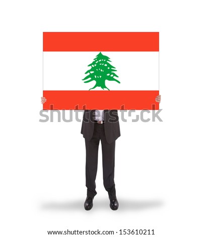 Businessman holding a big card, flag of Lebanon, isolated on white