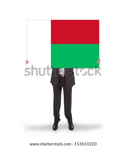 Businessman holding a big card, flag of Madagascar, isolated on white