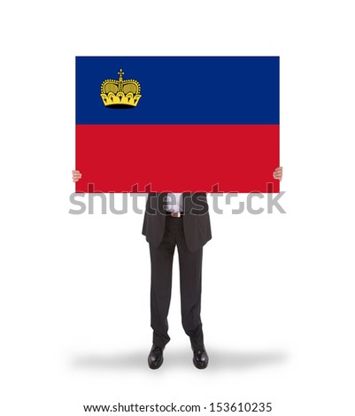 Businessman holding a big card, flag of Liechtenstein, isolated on white