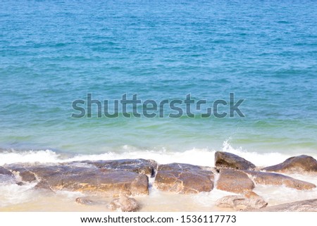 The rocks are at the coast and there are sea waves.