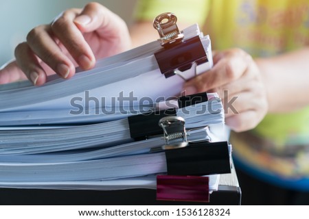 Stacks documents of paper files, Businessman hands working in messy bureaucracy and searching information on office, Accounting budget report file, arranging unfinished of paperwork on busy overwork