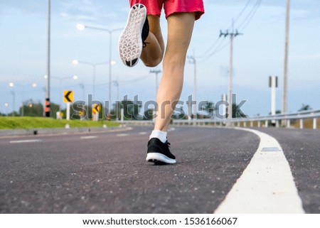 Movement. Woman legs running on asphalt road. 