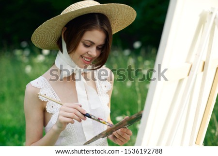 beautiful easel woman with a brush paints