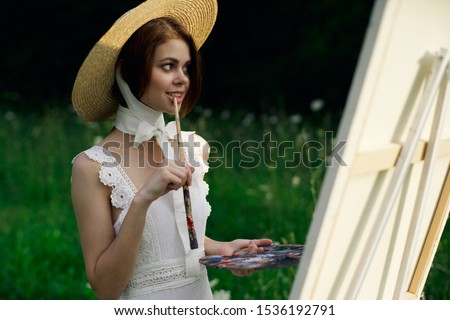 beautiful easel woman with a brush paints