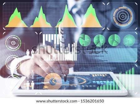 Digital tablet and financial graph with social network diagram and man hand with pen on background. Professional financial infographics and analytics. Modern smart technology in business