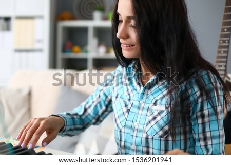 Portrait of wonderful musician studying new composition. Beautiful woman looking away with tenderness and gladness. Music and art concept. Blurred background