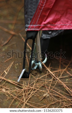 Red tent pegs put in the ground
