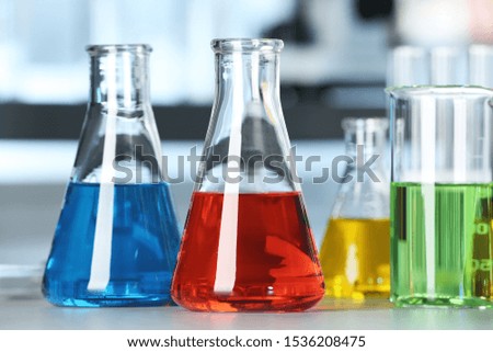 Glassware with colorful liquids on table in laboratory