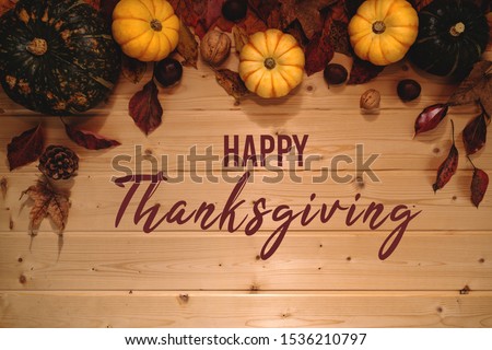 Happy Thanksgiving Day with pumpkin and nut on wooden background