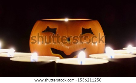 Pumpkin lamp base with candles in the night in black background. A Halloween holiday concept image with Jack lantern and candles.