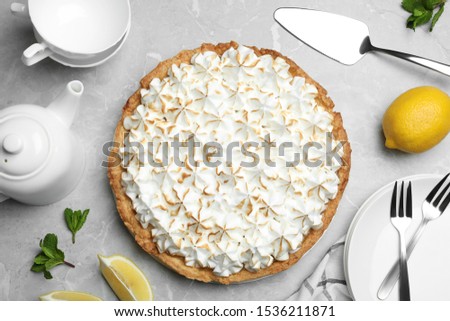 Flat lay composition with delicious lemon meringue pie on grey table