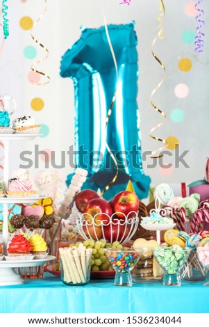 Dessert table in room decorated with blue balloon for 1 year birthday party