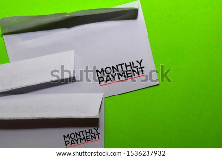 Monthly Payment on post card isolated on office desk background