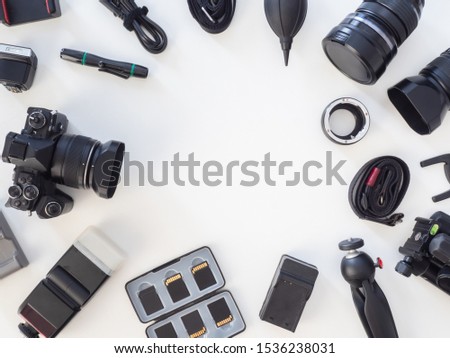 top view of work space photographer with digital camera, flash, cleaning kit, memory card, tripod and camera accessory on white table background