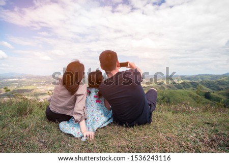 Happy asian family take photo by smartphone at the top of mountain