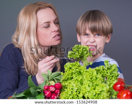 Little boy  refusing to eat green salad 