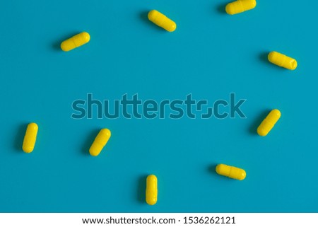 Yellow pills on blue background with copy space
