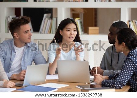 Multi-ethnic students working on common project thinking create new approach for challenge solution, group of classmates listening thoughts of Vietnamese girl, studying process and leadership concept Royalty-Free Stock Photo #1536299738