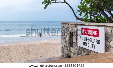 warning sign of no life guard on duty by the beach, shallow depth of field
