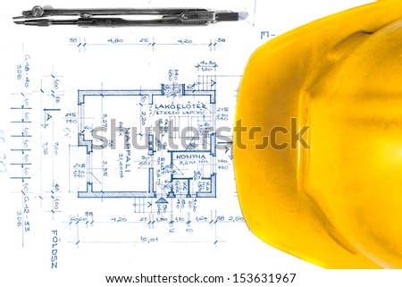Yellow helmet of an engineer with plans and bow