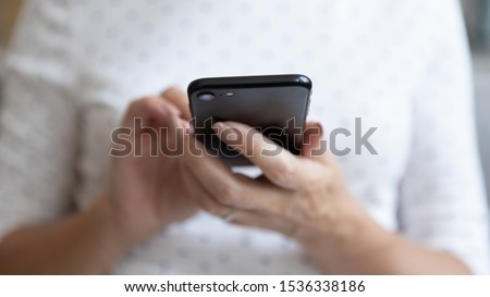 Senior middle aged woman holding modern device smart phone using mobile app, old elderly person female hands typing texting message online on cellphone, older people and tech concept, close up view