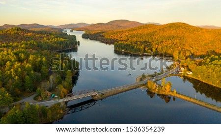The leaves are changing in Autumn along the lake and on the mountaintops at Long Lake Royalty-Free Stock Photo #1536354239