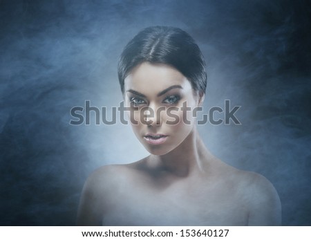 Portrait of young and beautiful woman over smoky background