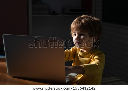Cute child prodigy developing app. Cute kid young programmer working on computer. Boy Hacker Programmer at data center filled with monitor.