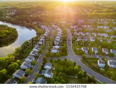 Aerial view of modern roofs of houses of residential area summer houses early sunrise Royalty-Free Stock Photo #1536425708