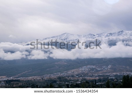 first snows in the mountains seen from the valley