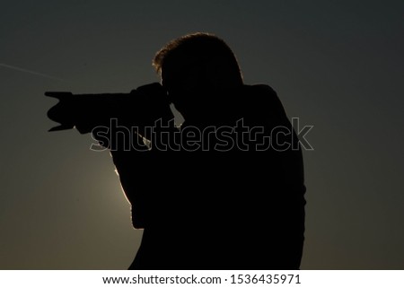 Photographing a photographer. Silhouette of photographer