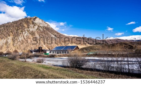 Beautiful mountain valley with stream and trees, Livingo village in background, Italy, Alps