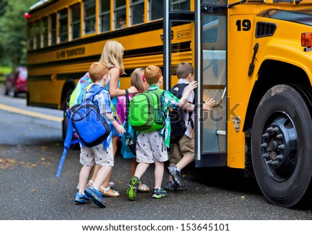 A group of young children getting on the schoolbus Royalty-Free Stock Photo #153645101