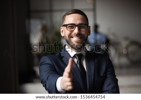Happy professional businessman consultant employer salesman wear suit extend hand at camera for handshake concept introduce greeting offering business collaboration partnership concept, close up view Royalty-Free Stock Photo #1536454754
