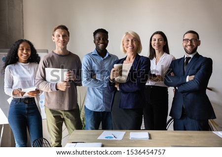 Happy confident diverse old and young business people stand together in office, smiling multiethnic professional colleagues staff group look at camera, human resource concept, team corporate portrait Royalty-Free Stock Photo #1536454757