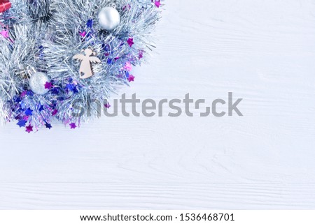 New Year 2020 flat lay from silver Christmas wreath with wooden angel on white textured background, selective focus. Christmas and New Year flat lay with shiny decorations on white backdrop 