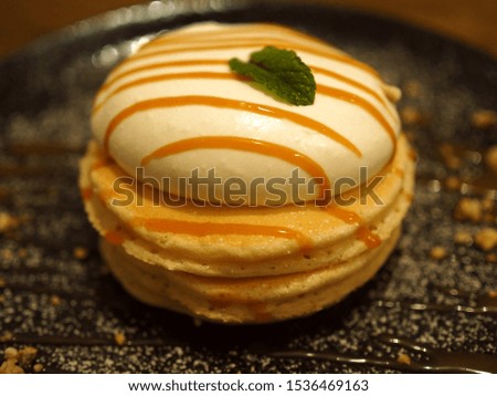 Stack of pancakes with honey and whipped cream and a mint on the top at the cafe Royalty-Free Stock Photo #1536469163