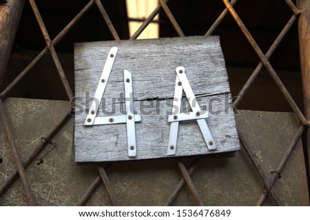 An interesting idea to make a house address sign from an aluminum plate on a wooden board. House number sign 4a.