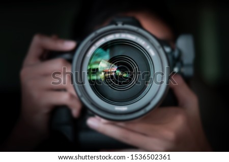 photographer  take pictures Snapshot with camera. man hand holding with camera looking through lens.Concept for photographing articles Professionally
