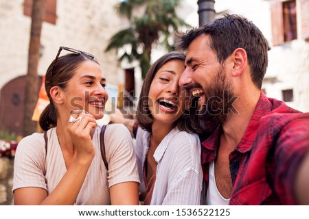 Smiling friends make looking at camera and make selfie
